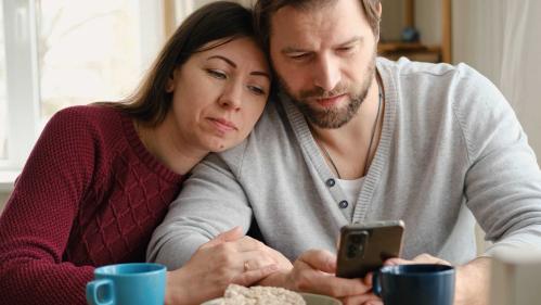 A romantic couple who are looking at their phone