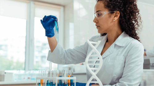 Woman in a lab coast holding a test tube in a lab setting