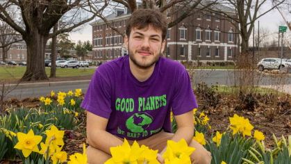 Rutgers senior Josh Kover crouches in a patch of daffodils outside Blake Hall in New Brunswick, N.J.