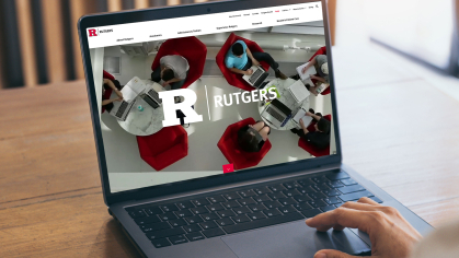 A person viewing the Rutgers website on a laptop