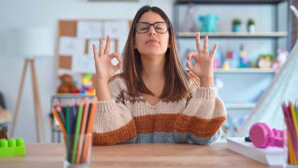 Teacher meditating at her desk 