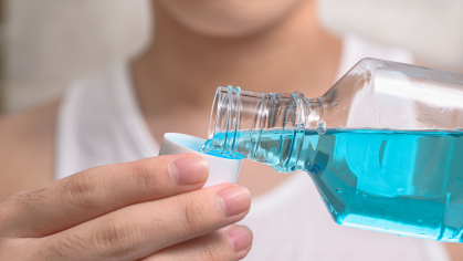 woman pours mouthwash