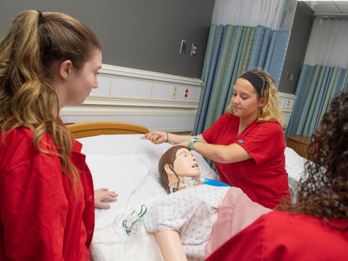 Nursing students practice on a simulation patient