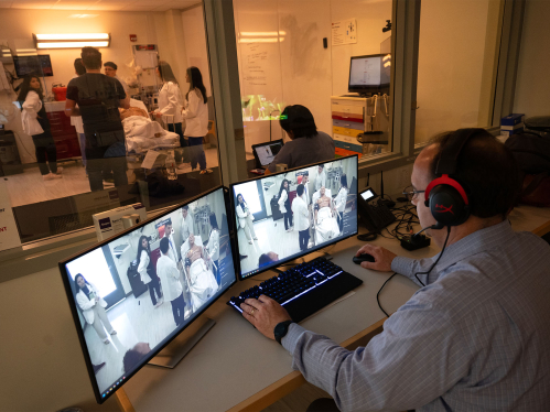 Leslie Barta, director Simulation Technology, monitors RWJMS students in the Pharmacy Simulation lab from the control room