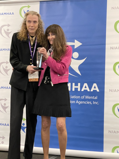 A rutgers faculty member accepting an award for their work in mental health