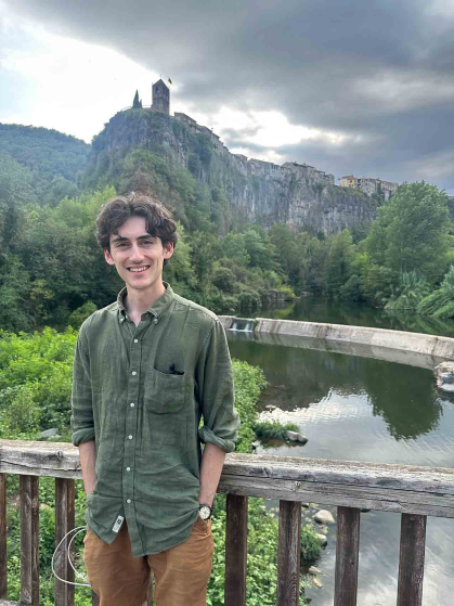 Rutgers graduate Joe Mezza stands before hilly, lush terrain in Catalonia, Spain.