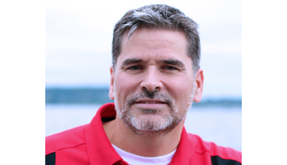 man in red shirt with ocean in background