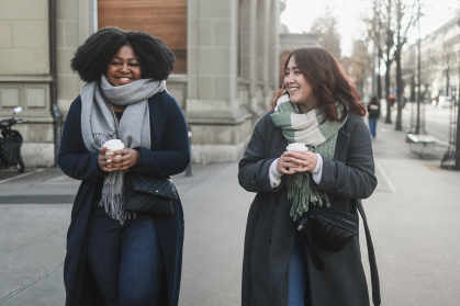 Two women walking with coffee