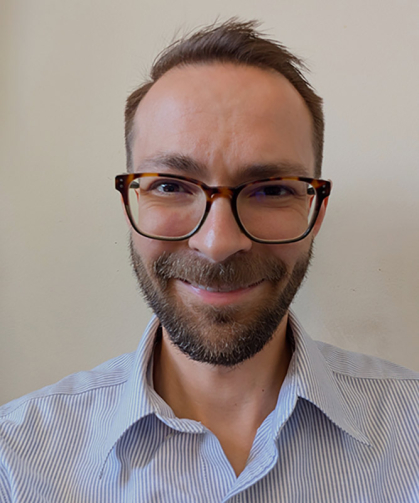 Smiling man with glasses wearing a blue shirt