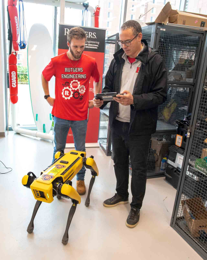 Patrick Rudawski (left), then a grad student, watches Rutgers President Jonathan Holloway operate a robot in Richard L. Weeks Hall during Rutgers Day 2023.