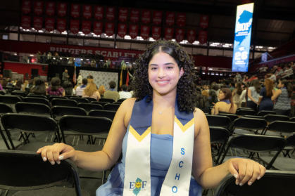 Steisy Gomez is seated with the stage behind her with wearing a sash, after the Achievement Award Ceremonh