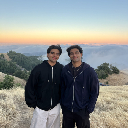 Daivik and Shrenik Patel standing on a mountain cliff